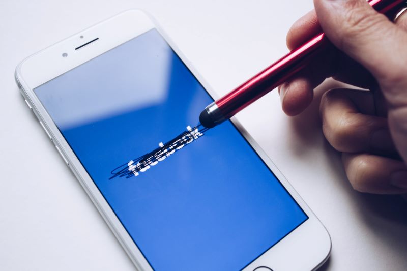 "Facebook" being scratched out on an iPhone.